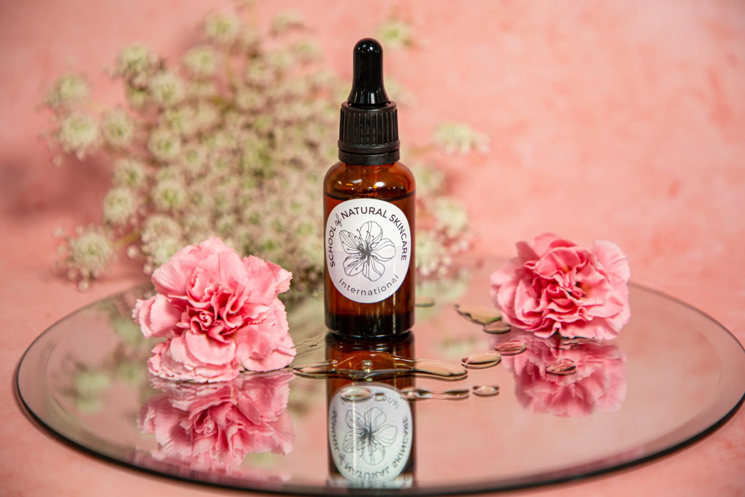 Natural skincare bottle with pink flowers on mirror