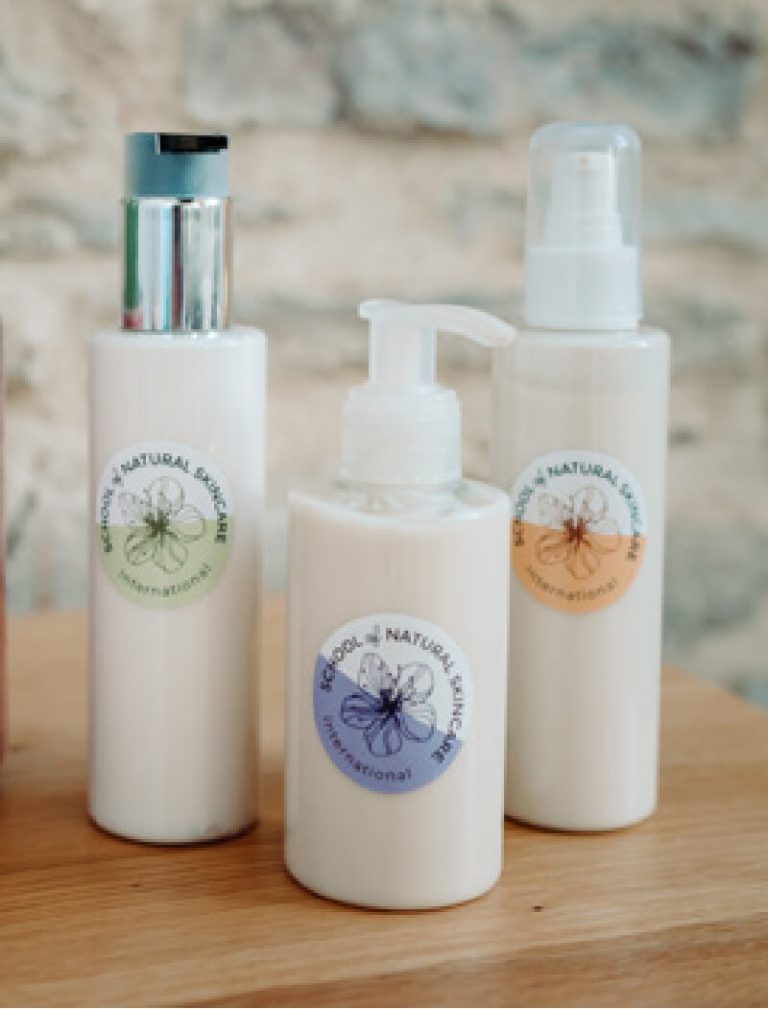 Natural skincare products in bottles on wooden surface.