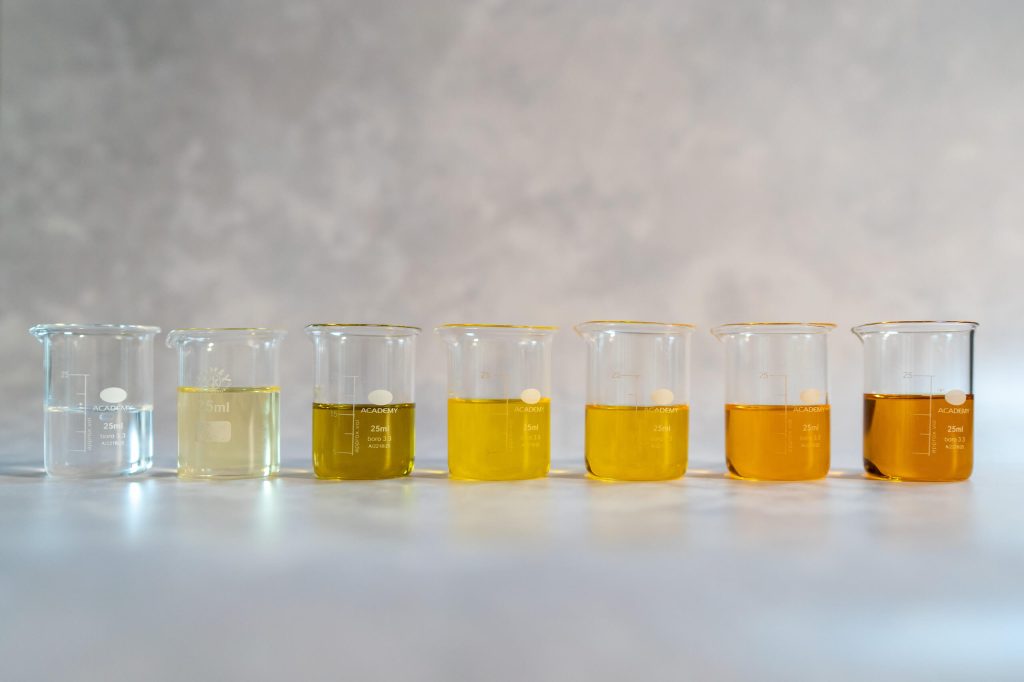 Seven beakers with various liquid colors in a row.