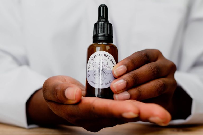 Hand holding natural skincare oil bottle