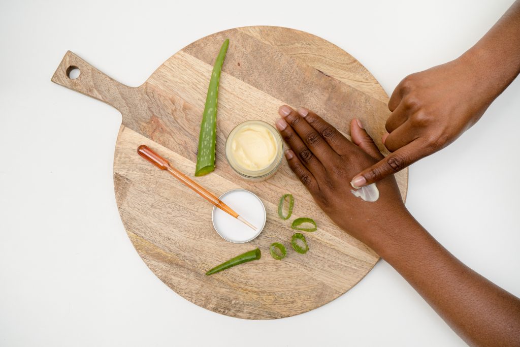 Applying aloe vera cream to hand