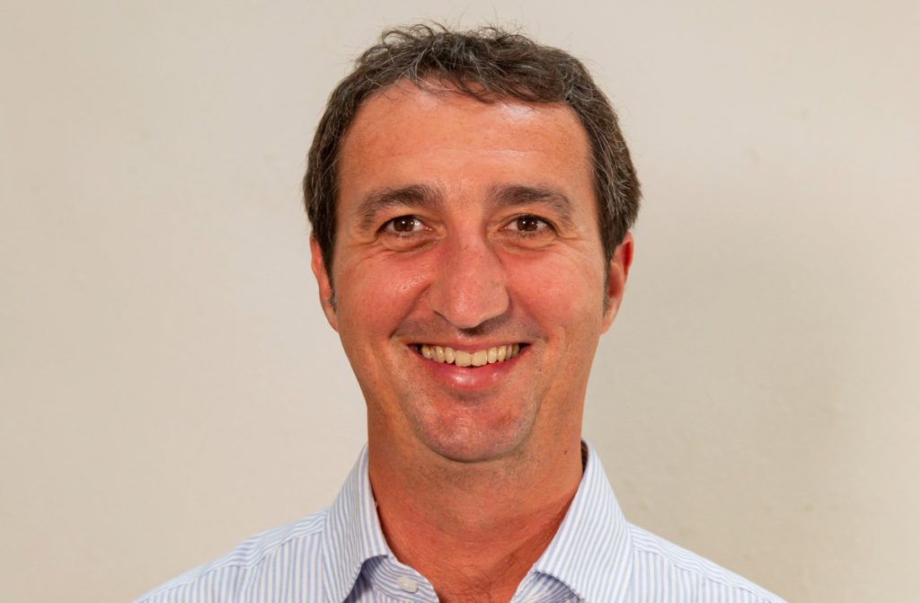 Smiling man in striped shirt portrait.