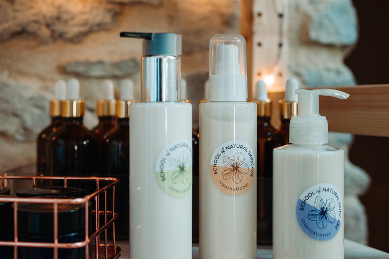 Natural skincare bottles on a wooden shelf.