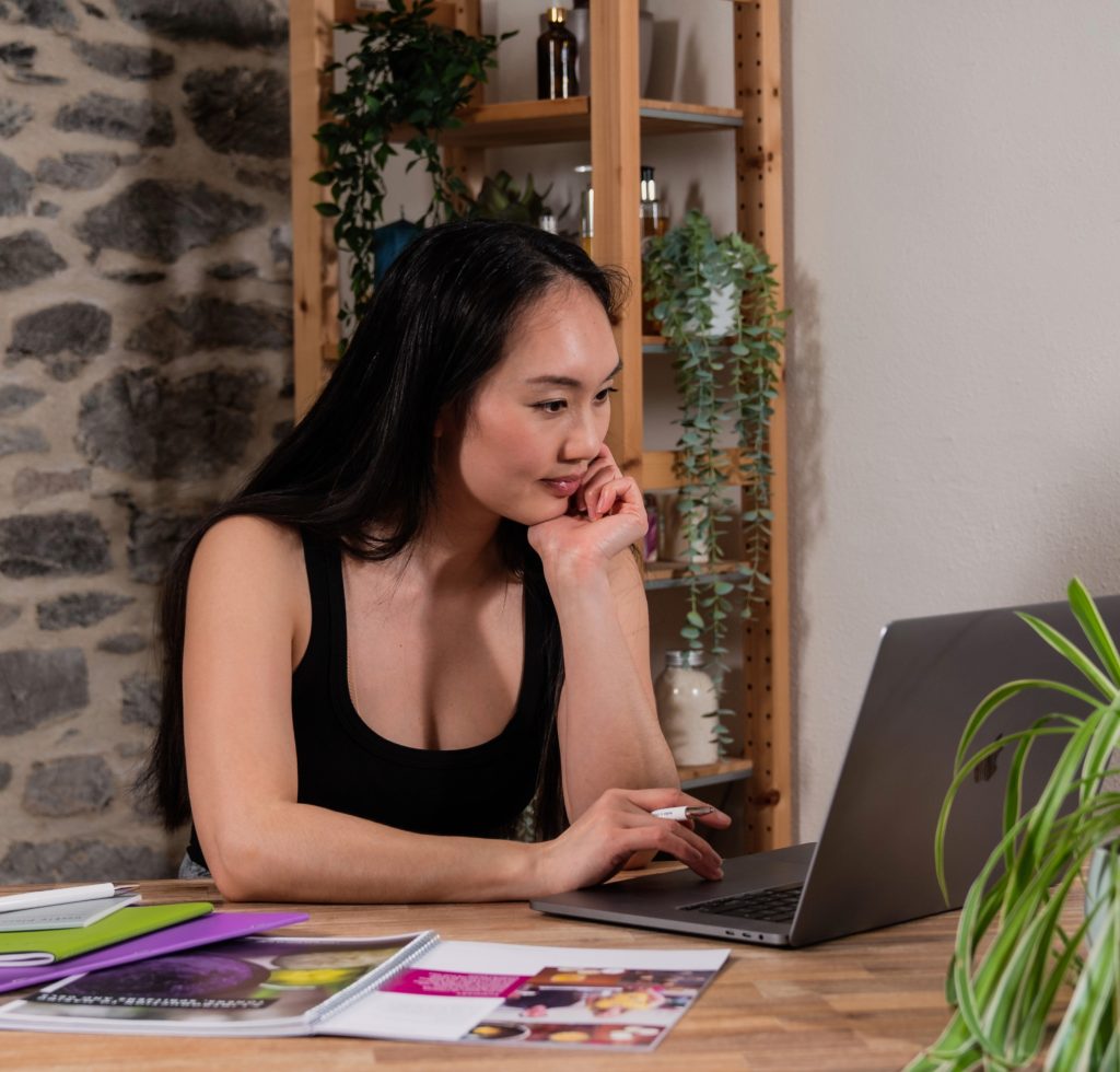 Woman working at laptop in cozy home office.