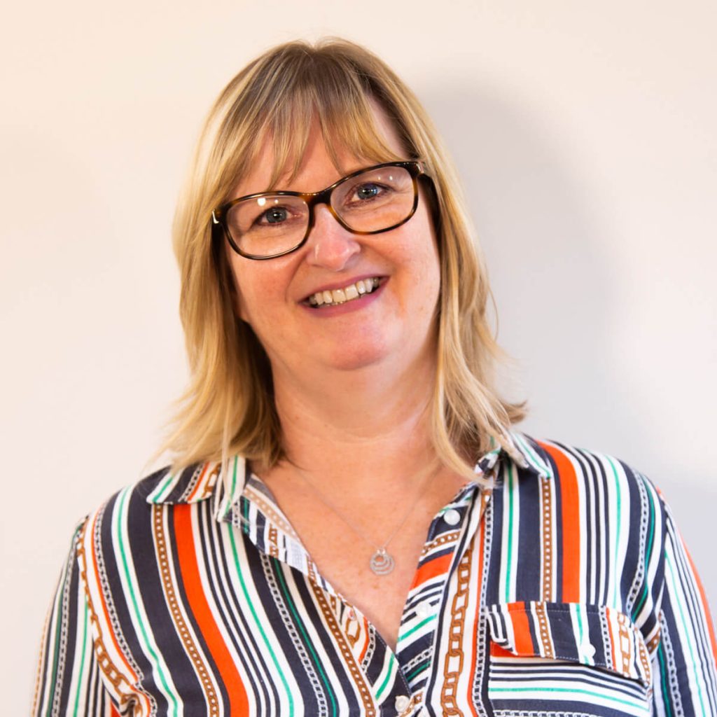 Smiling woman wearing glasses and striped shirt.