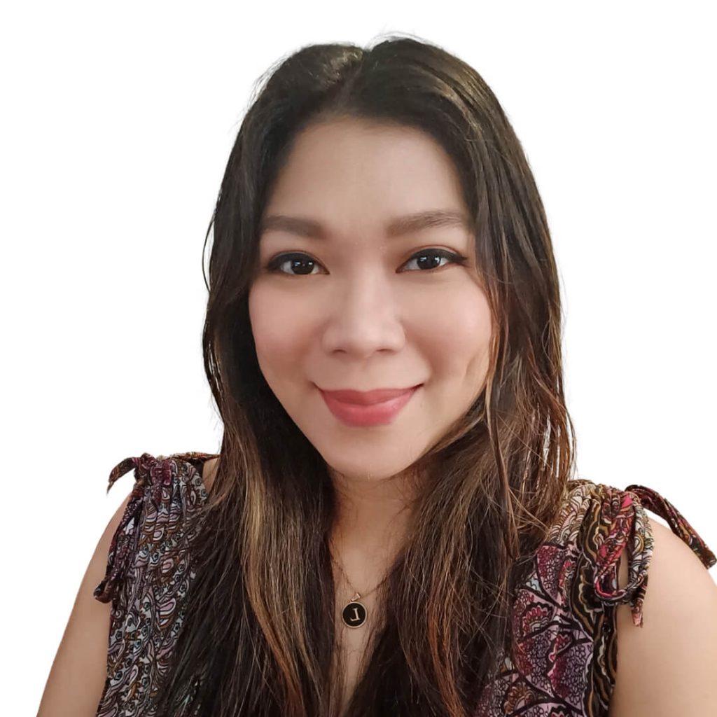 Smiling woman with long hair, patterned blouse.