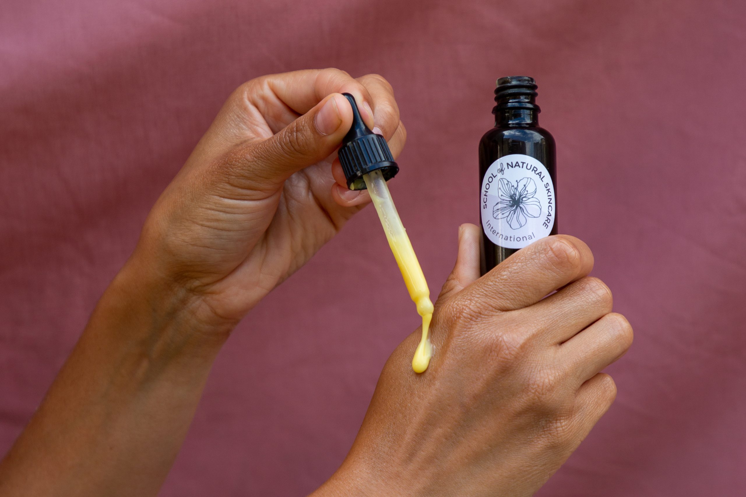 Applying natural oil with dropper to skin