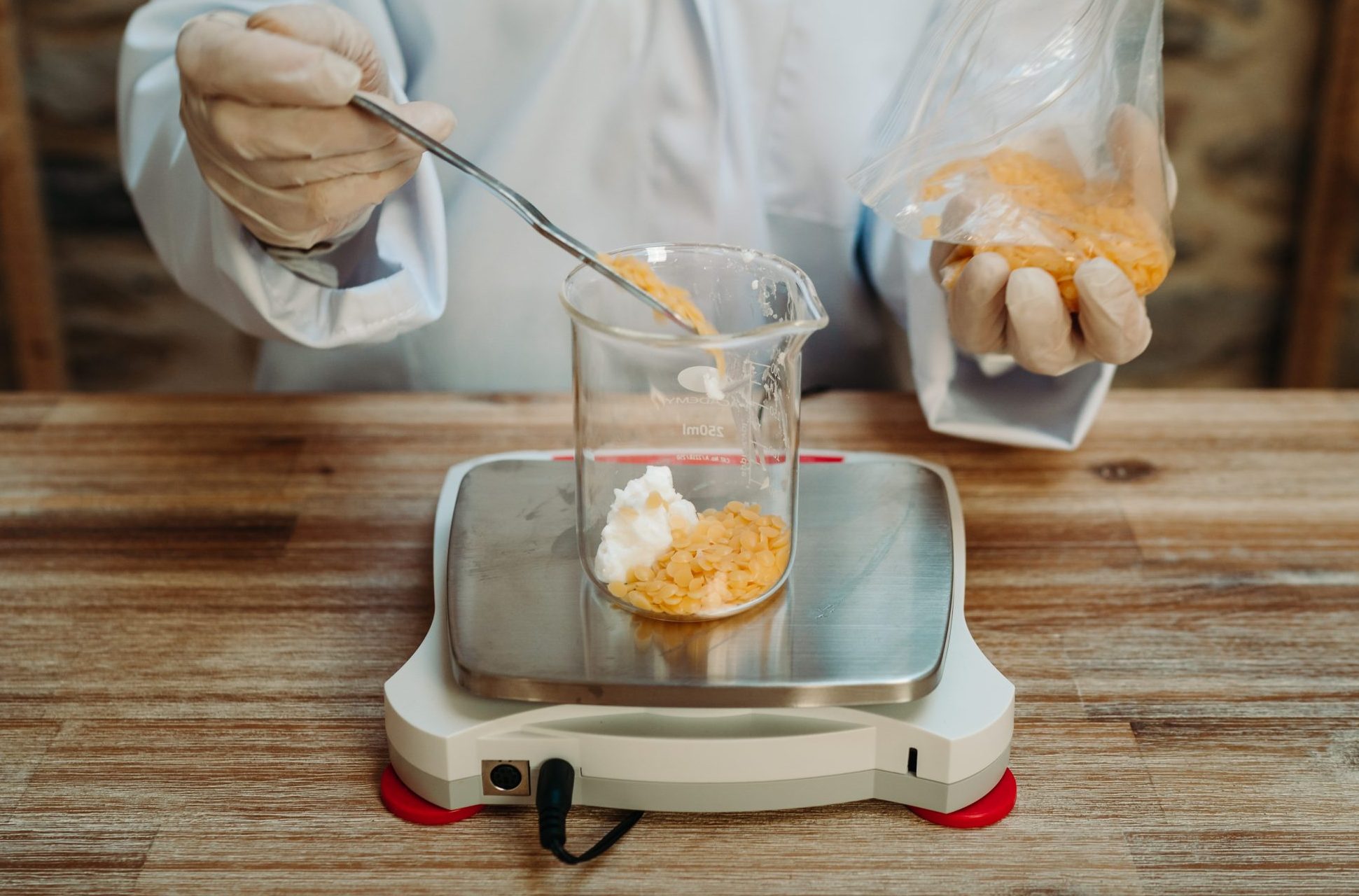 Mixing ingredients in a laboratory beaker on scale.