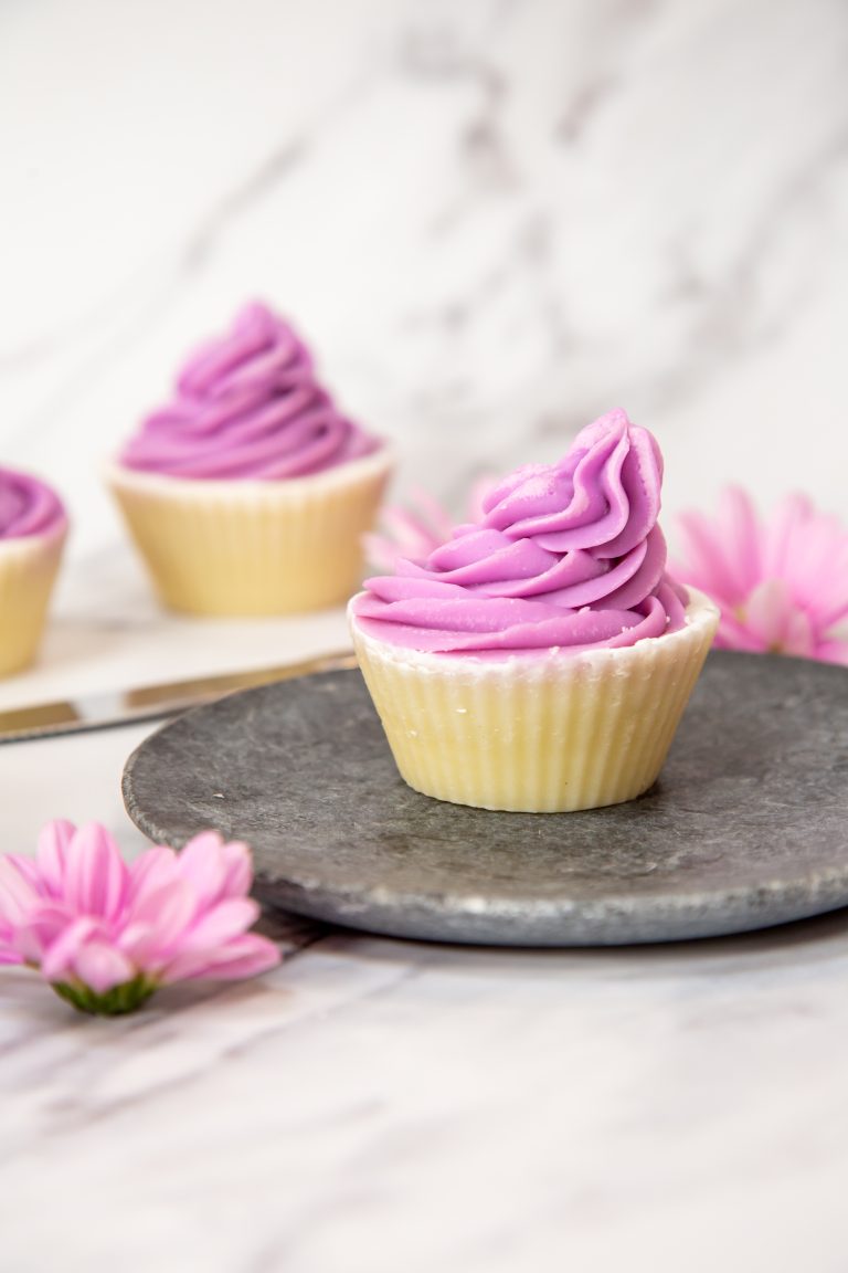 Purple frosted cupcakes on a stone plate