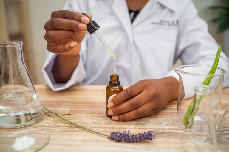 Person using dropper with essential oil bottle.