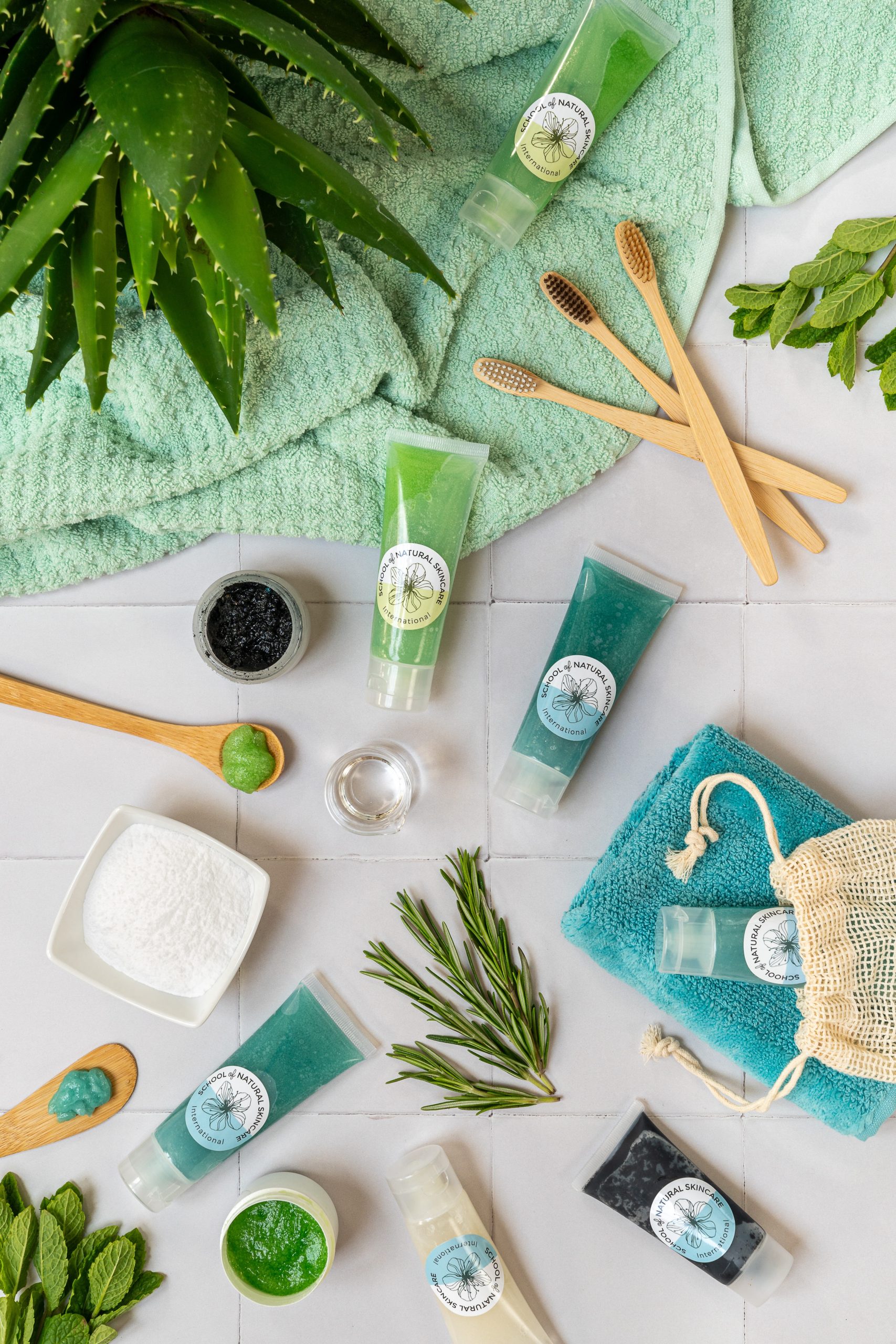 Natural skincare products with green plant on towel.