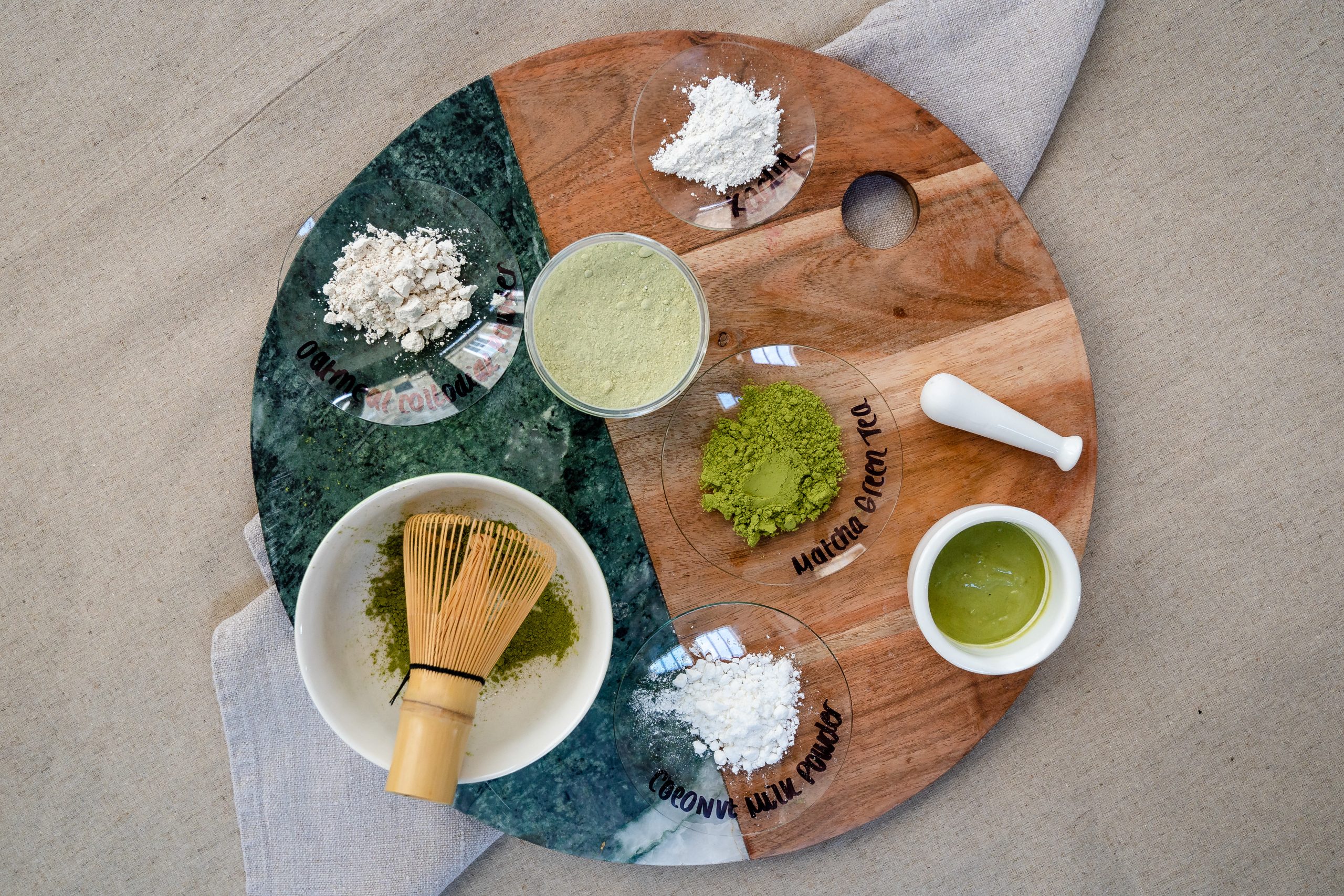 Matcha and ingredients on a wooden and marble board.