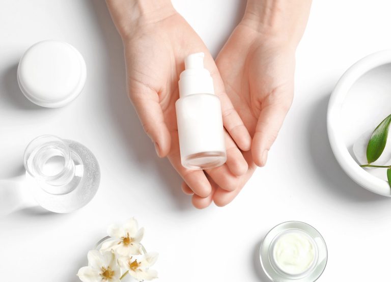 Hands holding a small white lotion bottle.