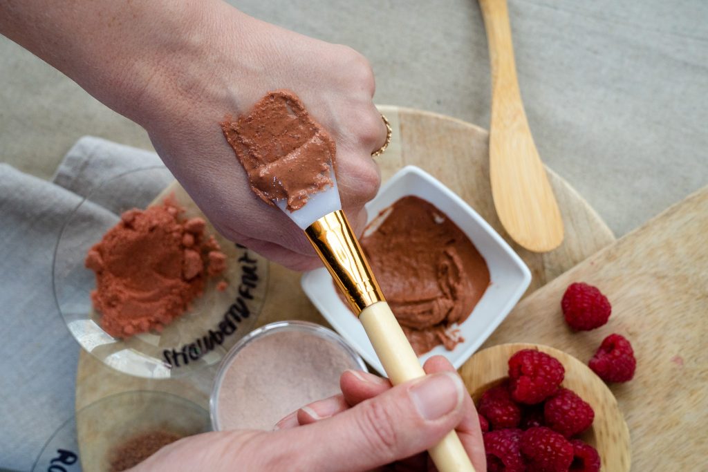 Applying raspberry face mask with brush