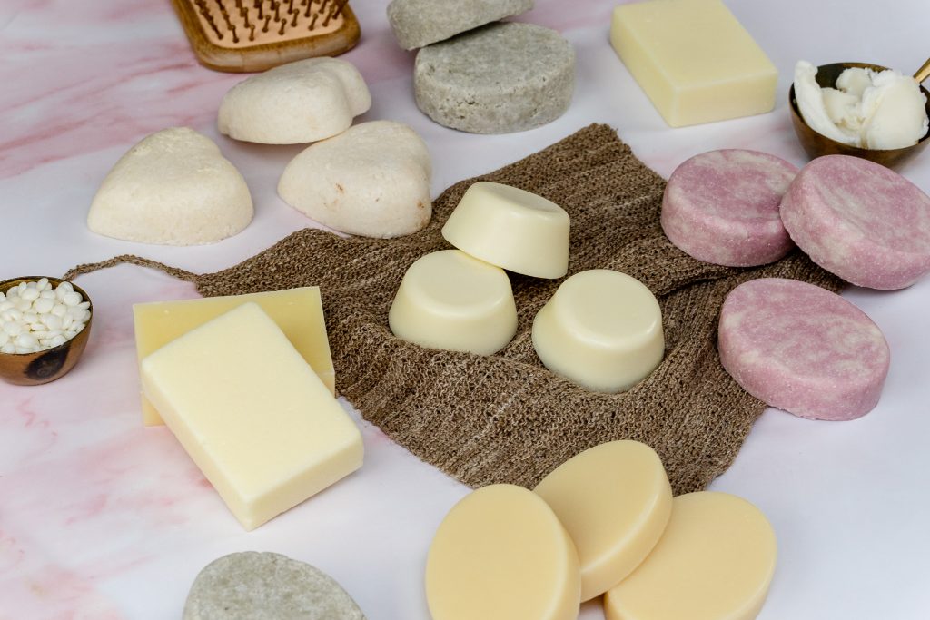 Various handmade soaps on a pink background