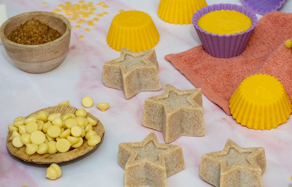 Assorted handmade soap bars and ingredients displayed.