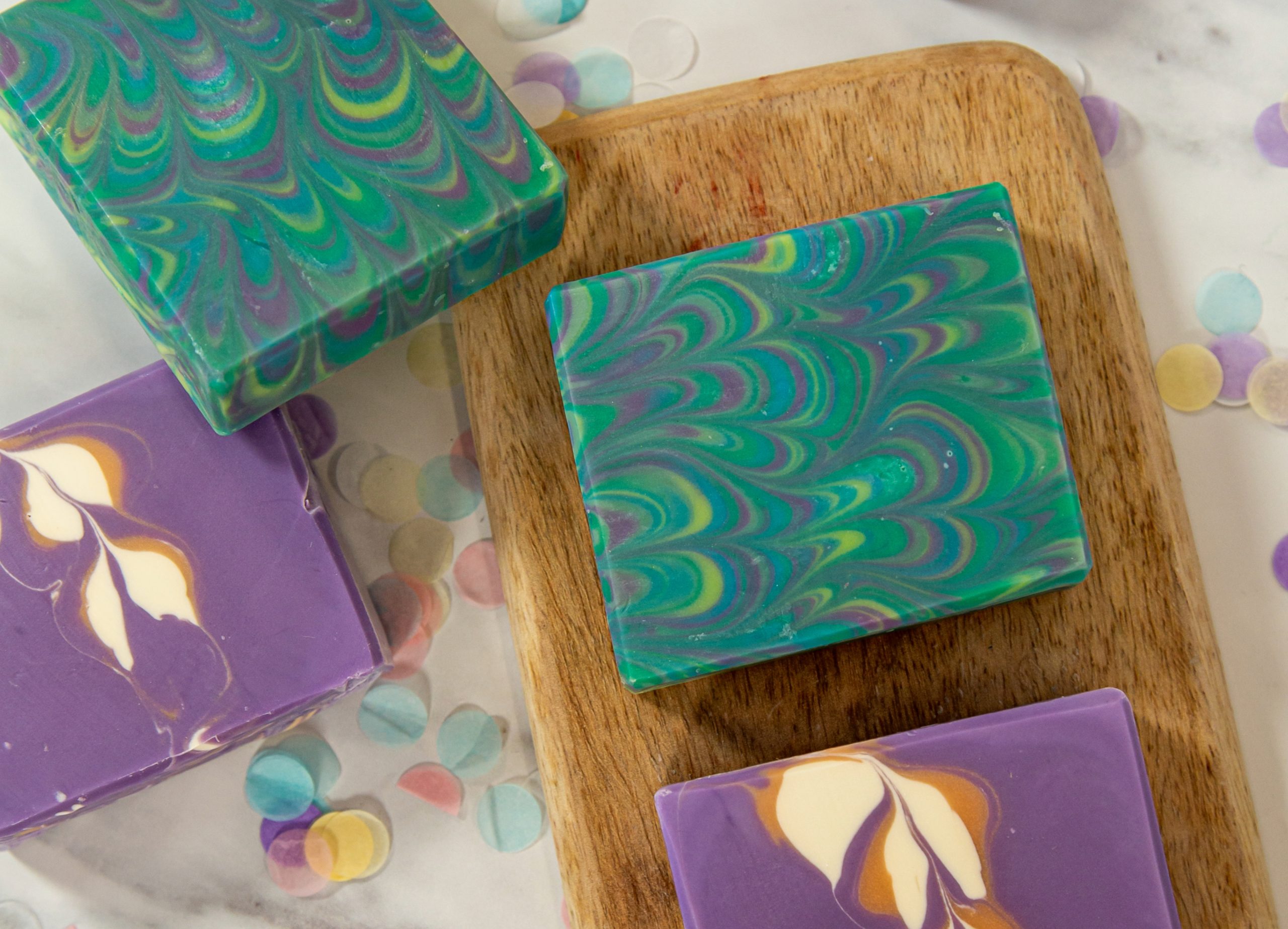 Colorful handcrafted soap bars on wooden board