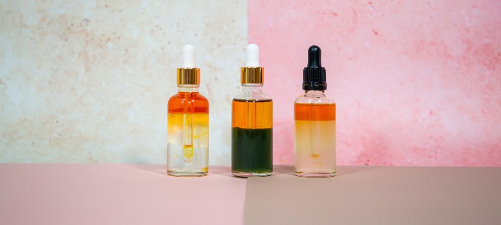 Three serum bottles on textured background