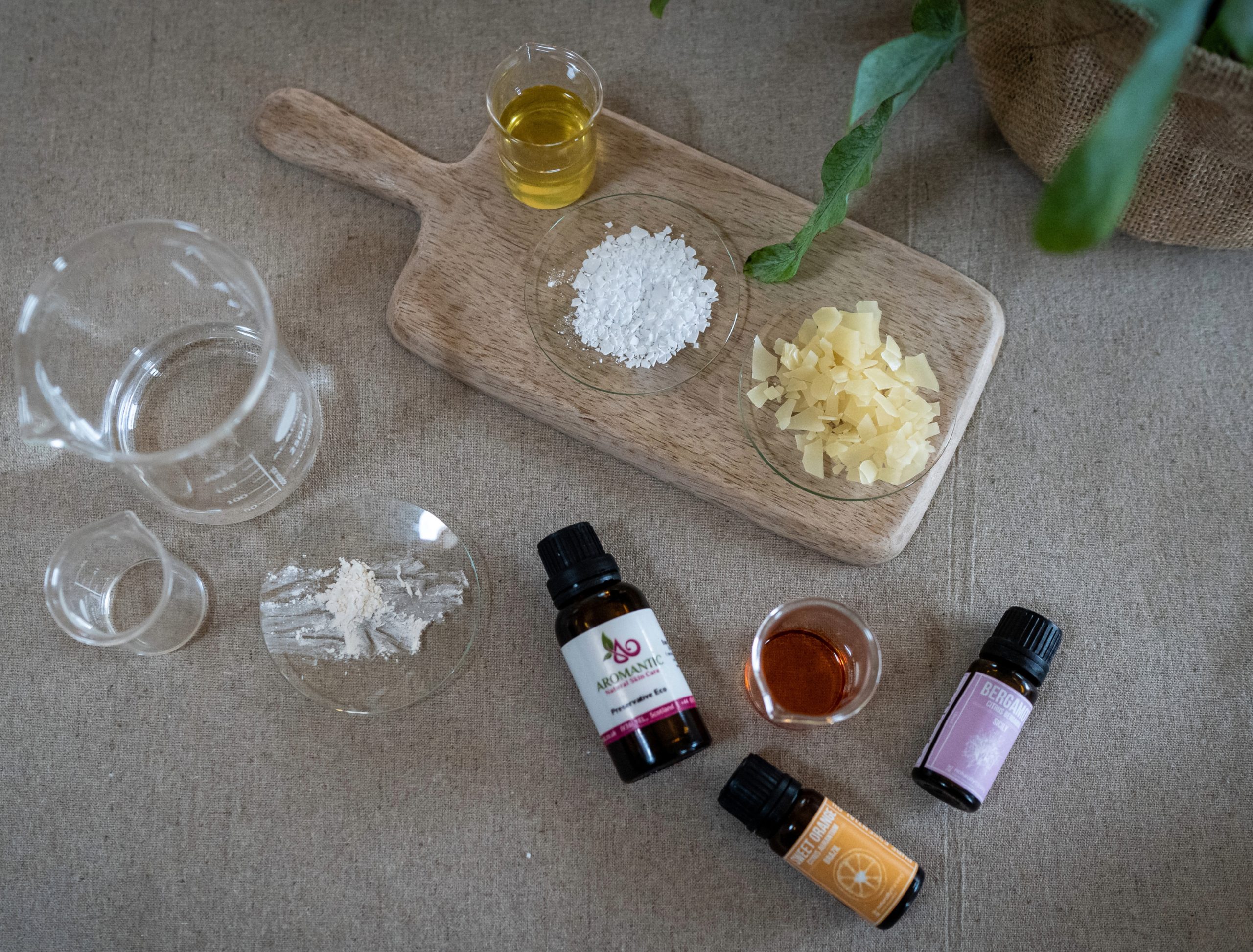 Skincare ingredients and essential oils on a wooden board.