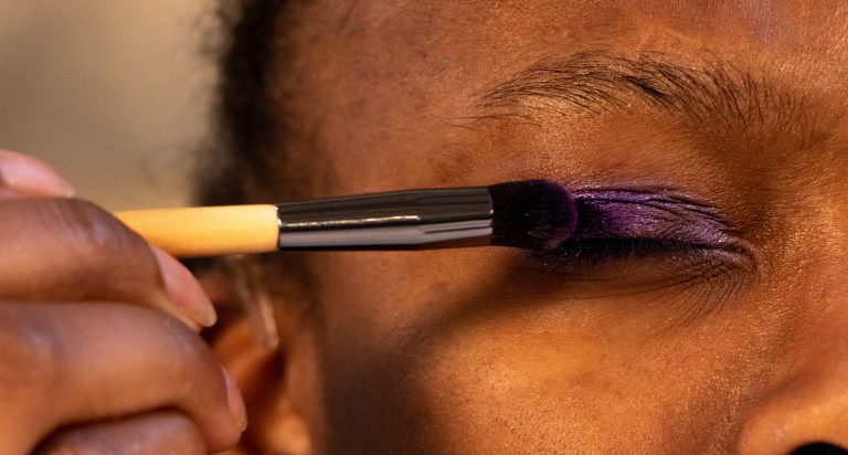 Applying purple eyeshadow with brush