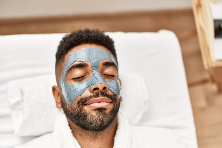 Relaxed man with a facial clay mask.