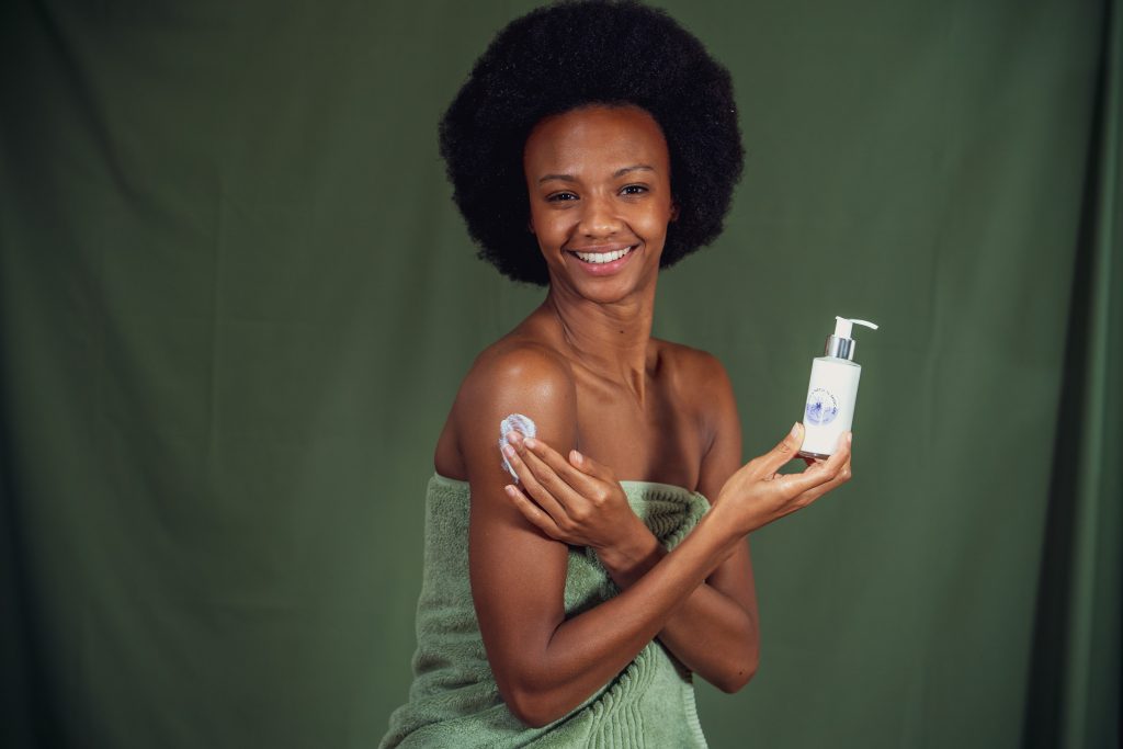 Woman applying lotion with a smile