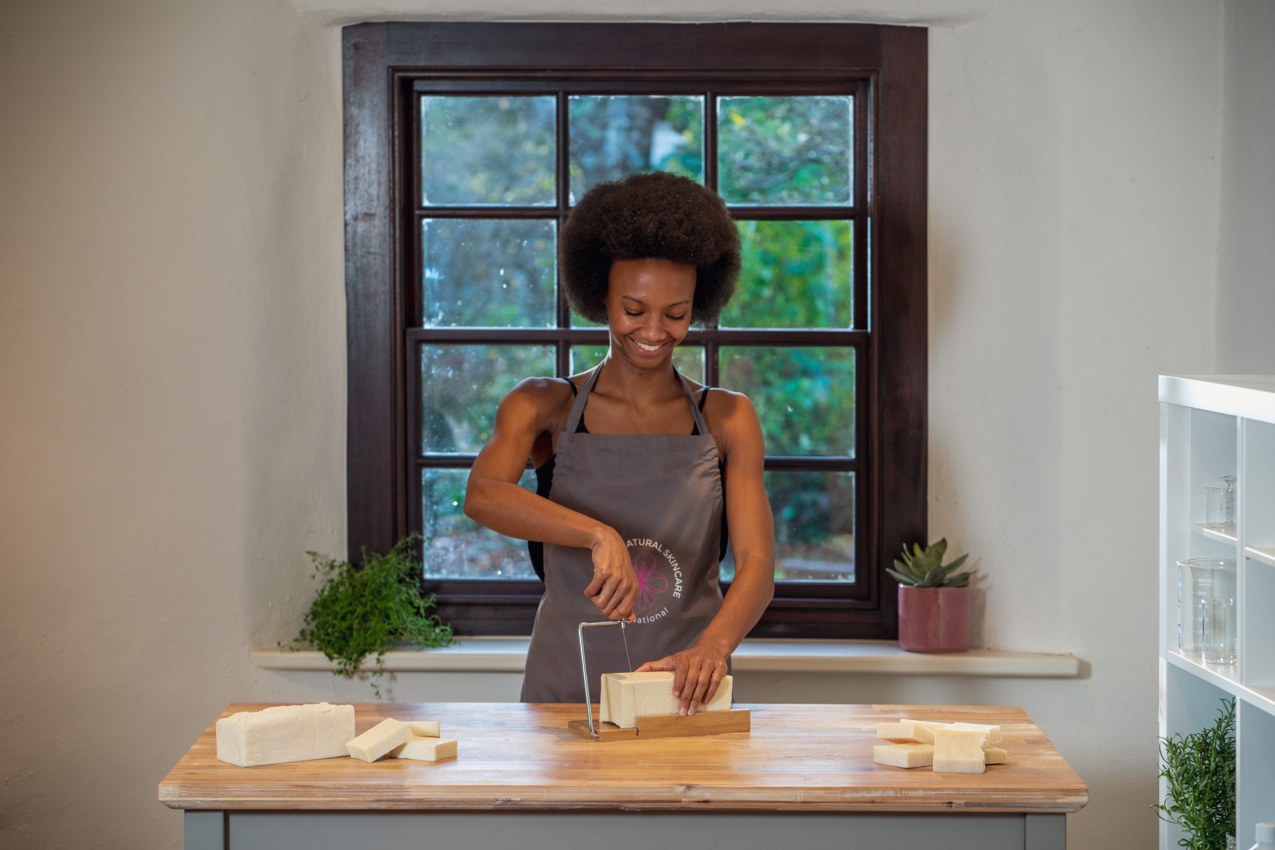 Woman slicing natural soap with a wire cutter.