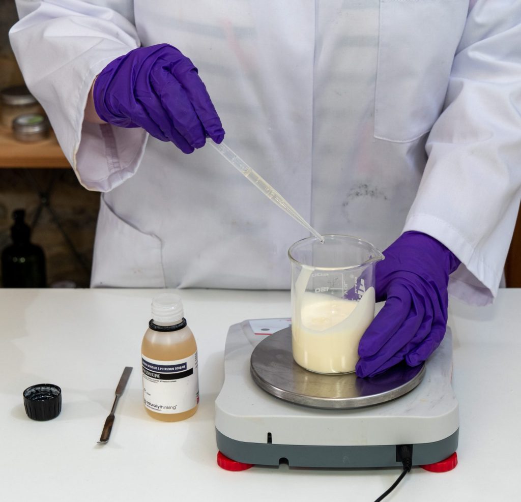 Scientist mixing chemicals in a laboratory beaker.