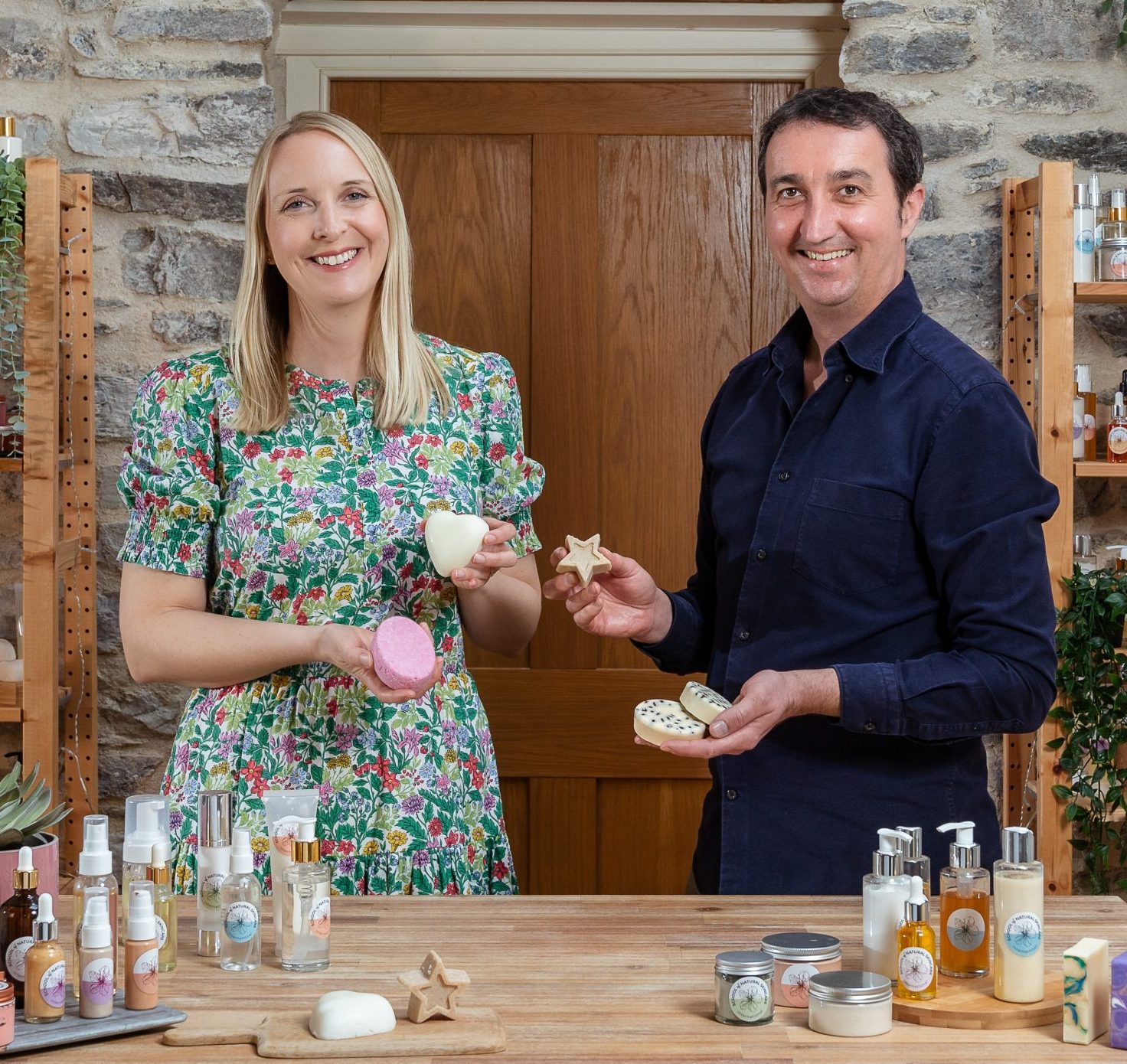 Two people with handmade soaps and cosmetics.