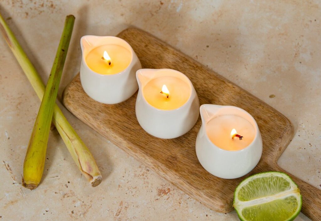 Three lit candles with lemon and lemongrass