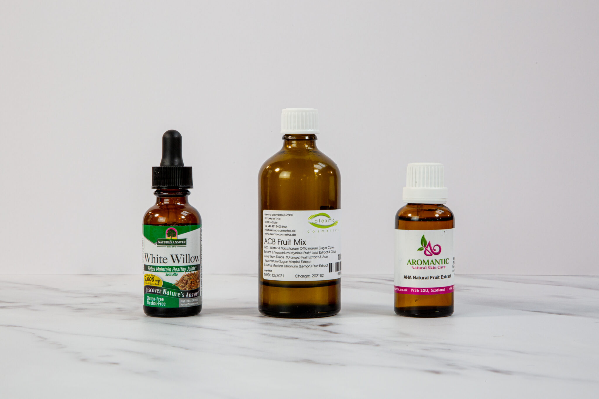 Three bottles of herbal supplements on white background.