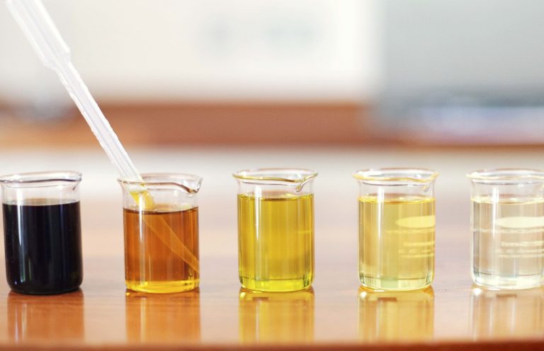 Different oil samples in glass beakers.