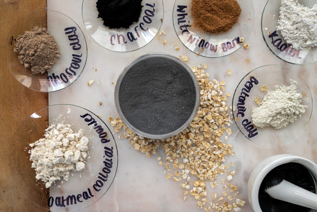 Various natural clays and powders on glass plates.