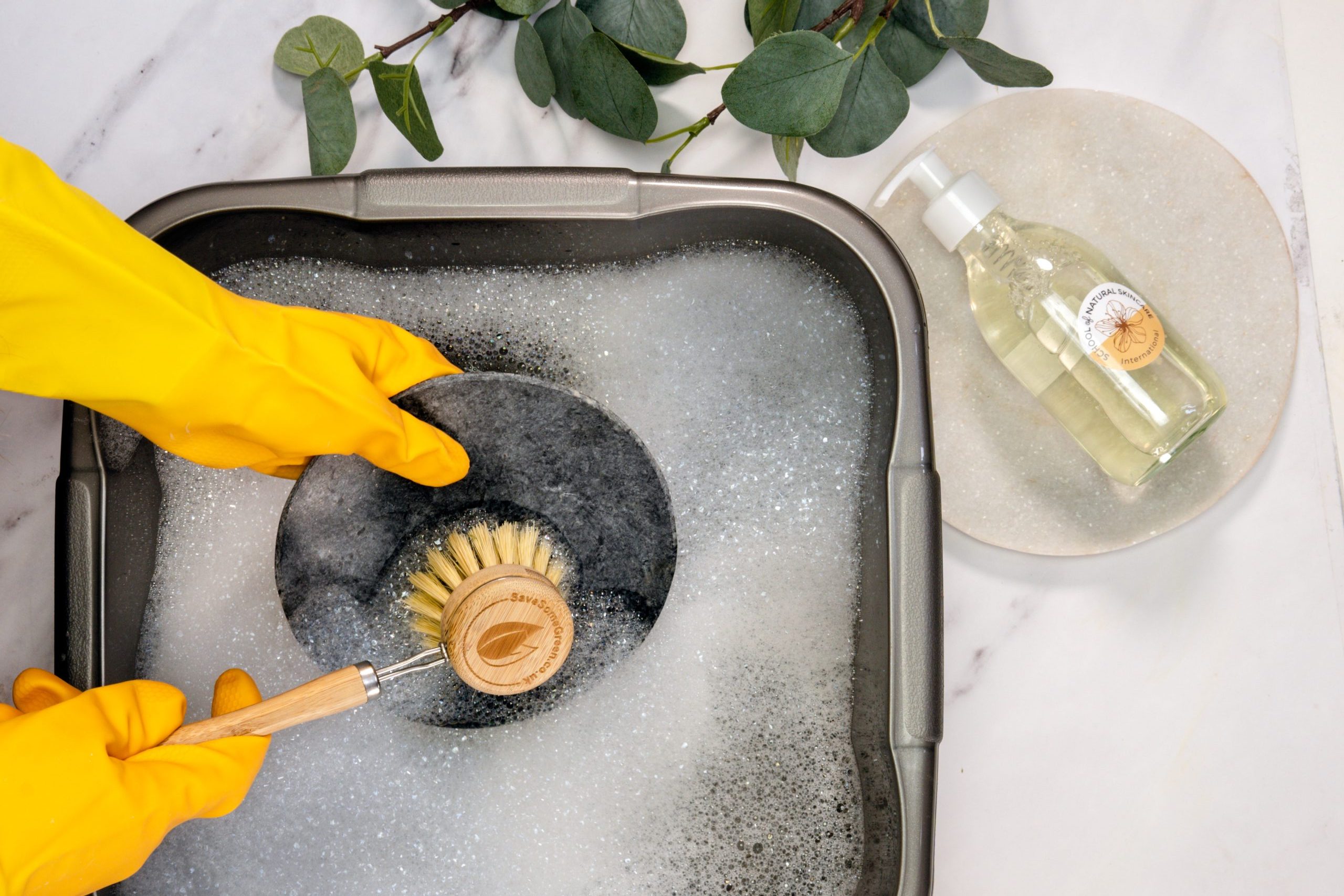 Washing dishes with eco-friendly soap and brush