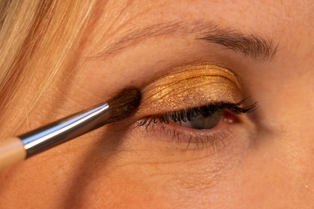 Applying gold eyeshadow with brush