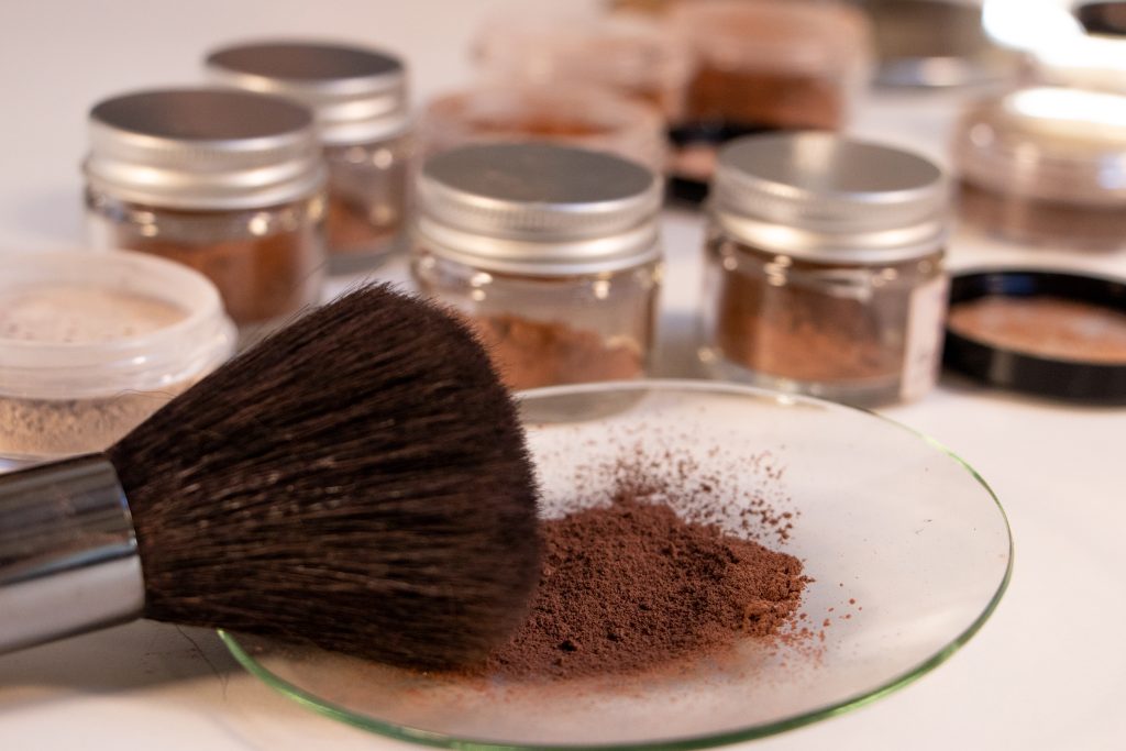 Loose powder makeup with brush and jars.