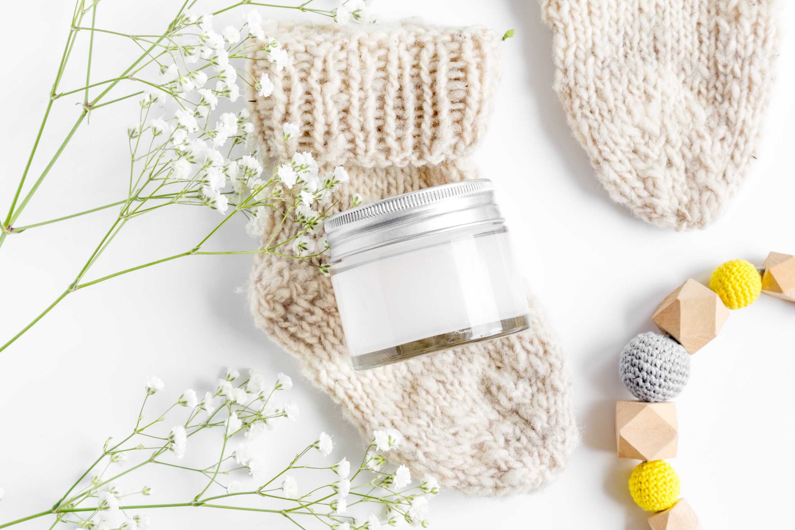 Baby socks, cream jar, flowers and beads