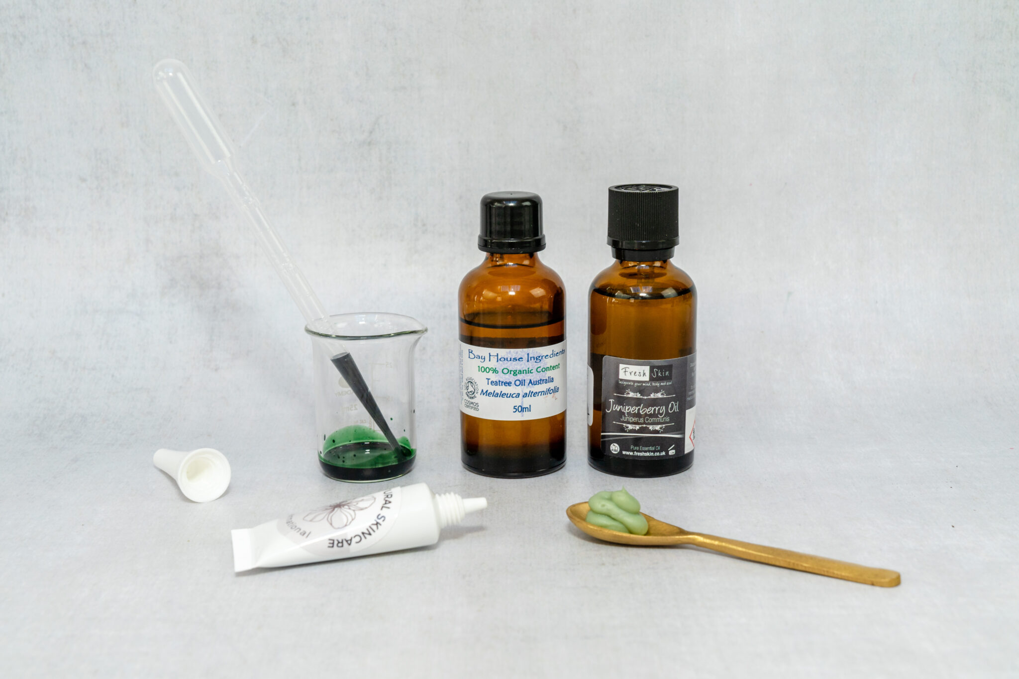 Natural skincare oils and mixing tools displayed.