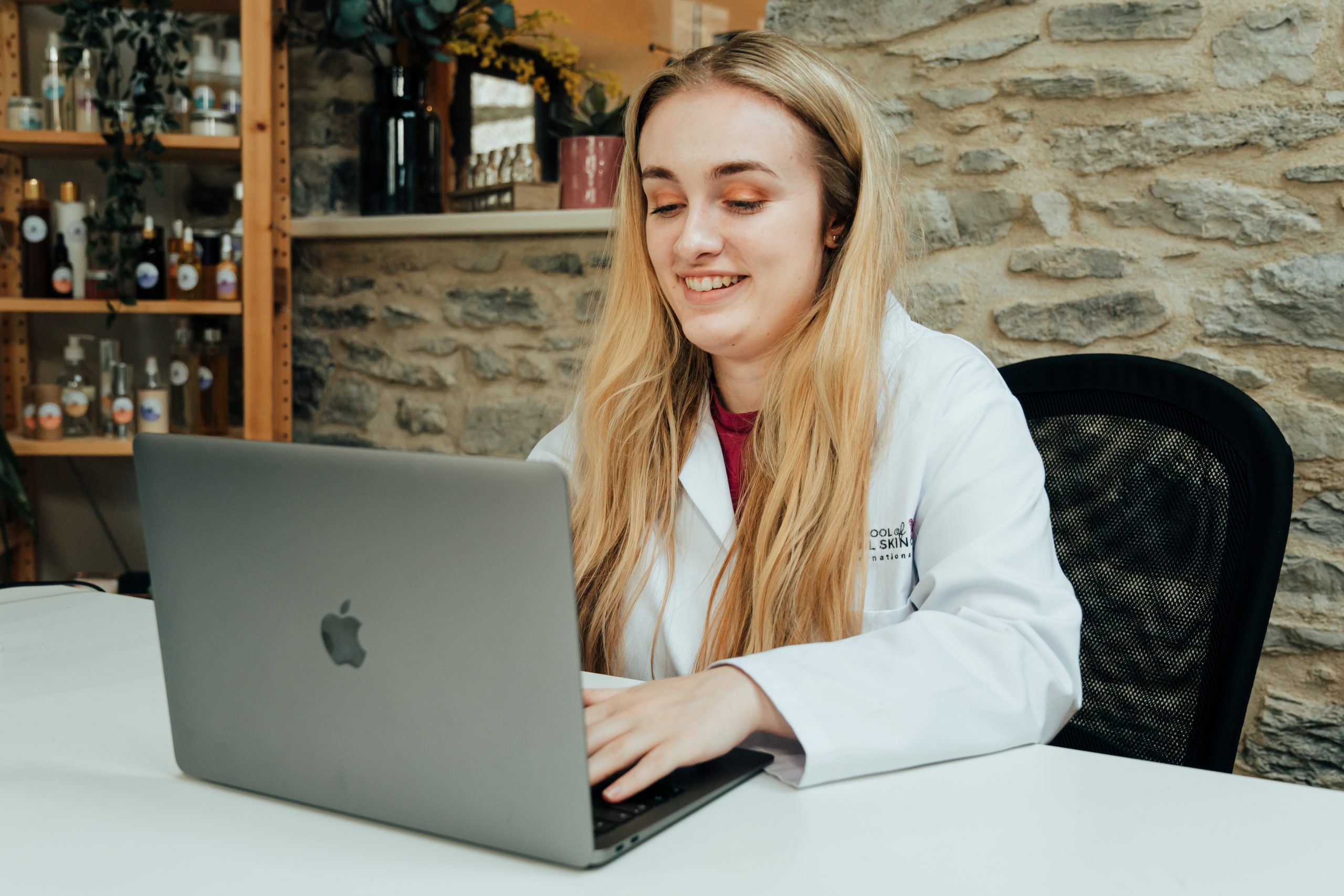 Woman in white coat working on laptop