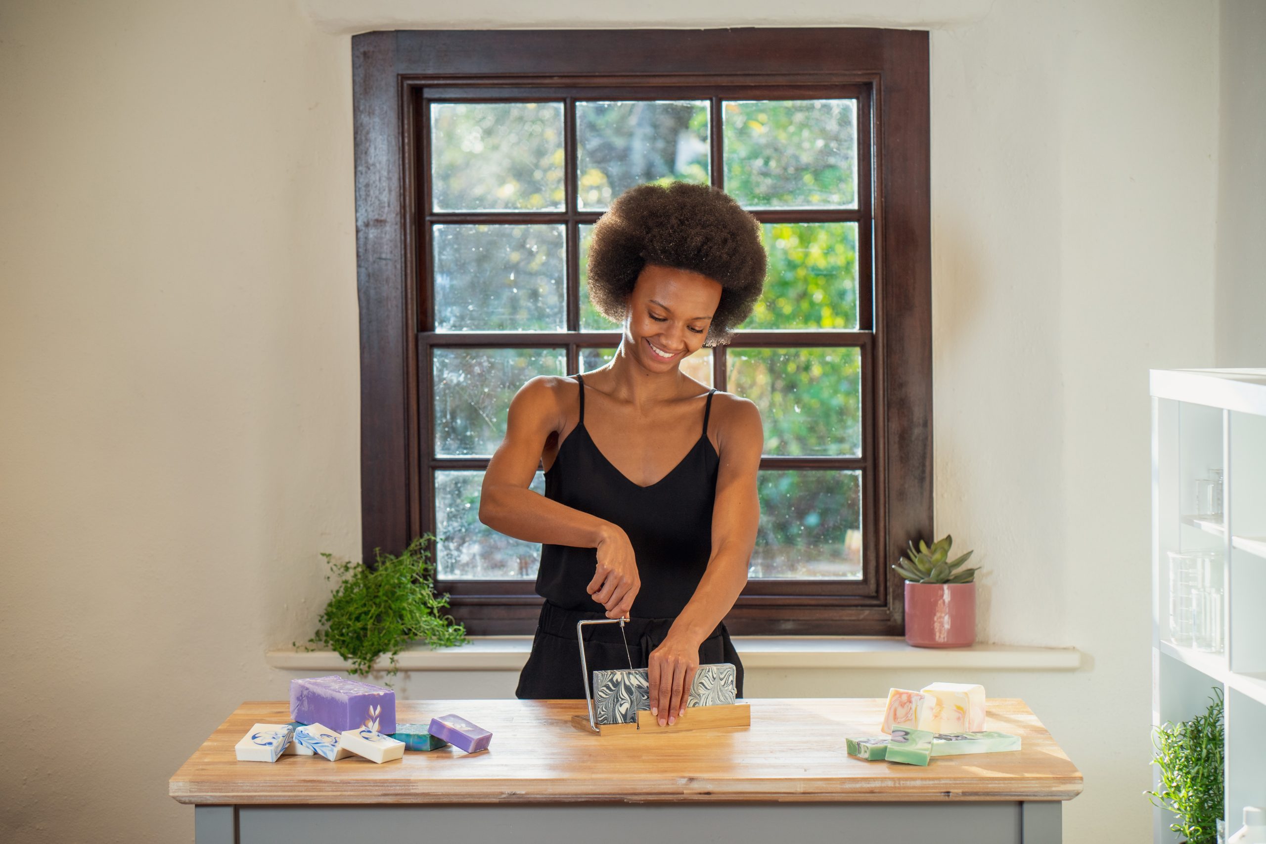 Person cutting handmade soap in bright kitchen