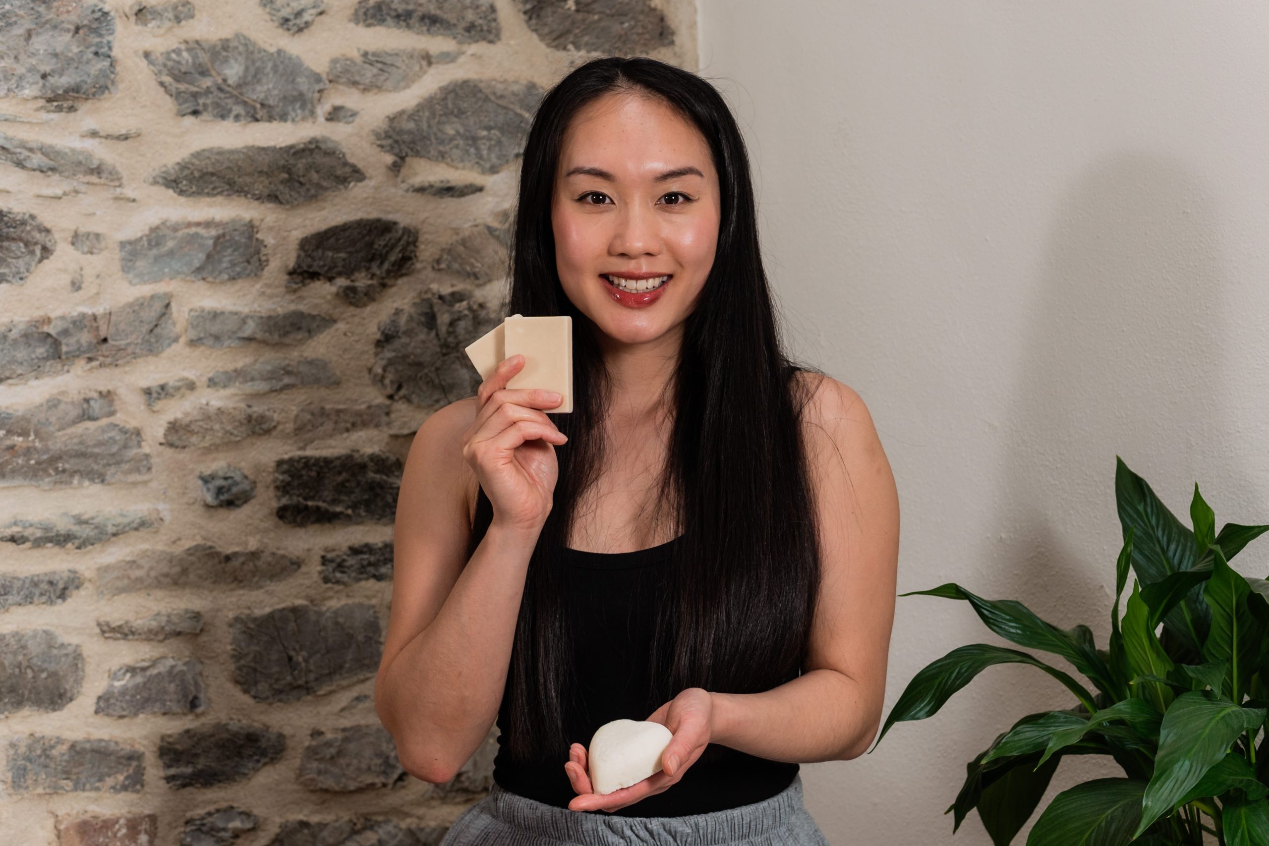 Woman holding soap bars near stone wall