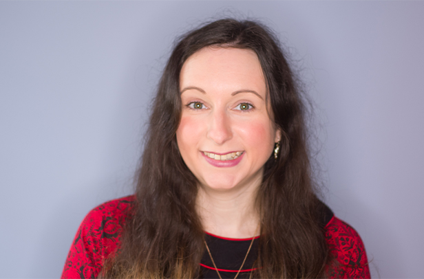 Smiling woman with long hair and red top.