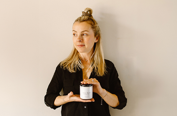 Woman holding a skincare product.